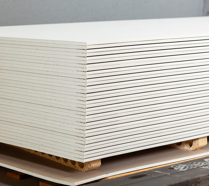 Stacking of white gypsum panels, drywall or plasterboard.