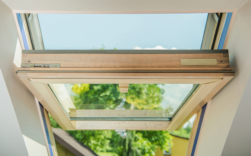 Closeup of an Open Wooden Roof Window. Brand New Installation at Residential Building.