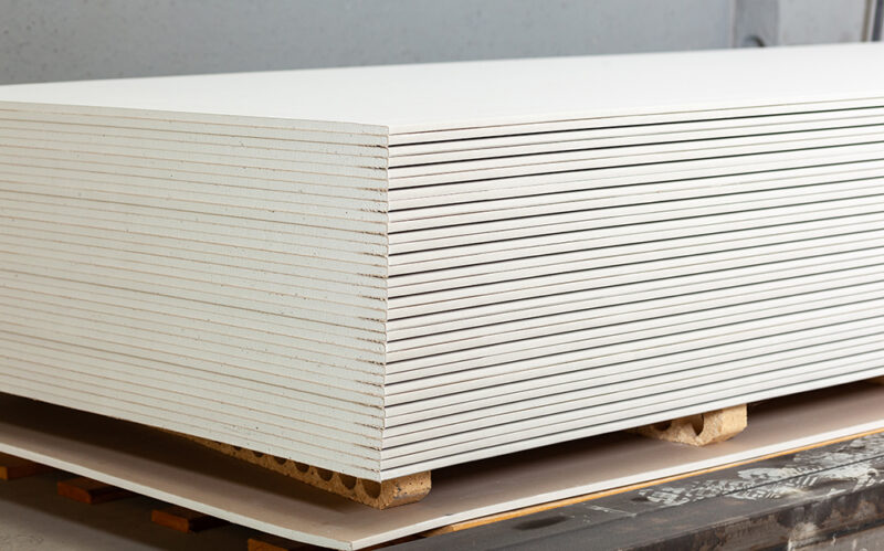 Stacking of white gypsum panels, drywall or plasterboard.