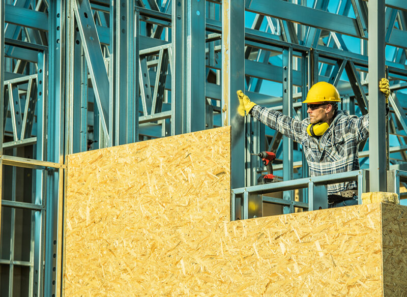 Caucasian Construction Worker on a Newly Developed Skeleton Steel Frame Building. Industrial Concept.